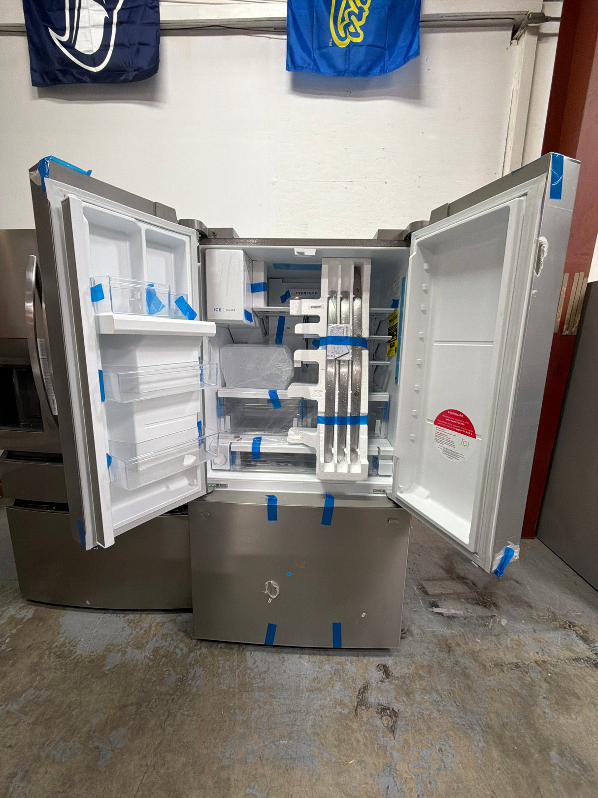 Frigidaire FRFC2323AS - 23 Cu. Ft. Counter-Depth French Door Refrigerator - Scratch & Dent open with storage compartments.